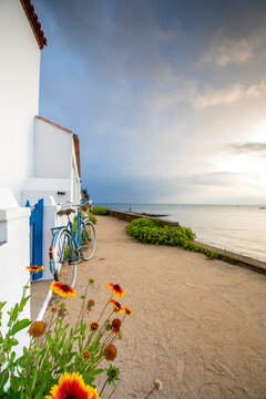 Vieux vélo bleu au bord de la plage le long des maison blanches de l'île de Noirmoutier en Vendée, France.