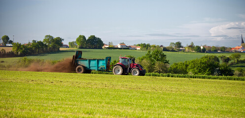 Paysage de campagne, agriculteur pendant l'épandage d'un champ au printemps.