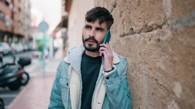 Young hispanic man smiling confident talking on the smartphone at street