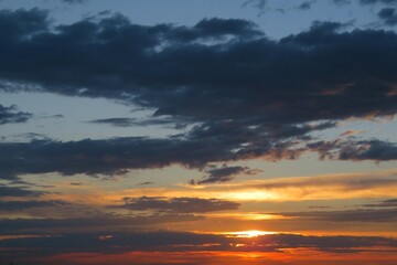 Fototapeta na wymiar Beautiful orange colorful sunset background with black clouds