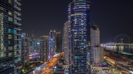 Panoramic view of the Dubai Marina and JBR area and the famous Ferris Wheel aerial night timelapse