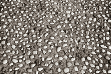 Decorative background of small pebbles in concrete. Pavement made of pebbles and concrete mixture. Texture of pebbles for poster, branding, calendar, card, banner, cover, space for your design or text