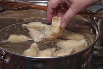Fototapeta premium putting dumplings in a pot of boiling water