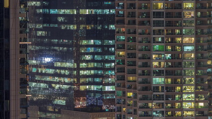 Fototapeta na wymiar Windows of apartment and office buildings at night timelapse, the light from the windows of houses