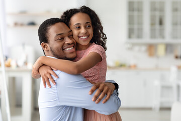 Loving black family father and daughter hugging, copy space