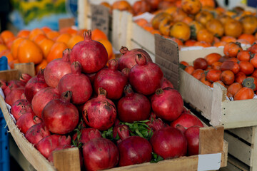 Red ripe pomegranate on the counter of a street vegetable store