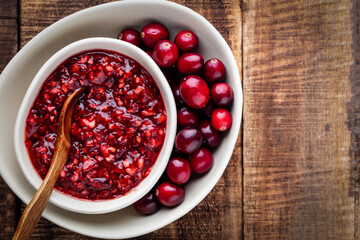 Red cranberries on wooden background. Brries in a bowl.