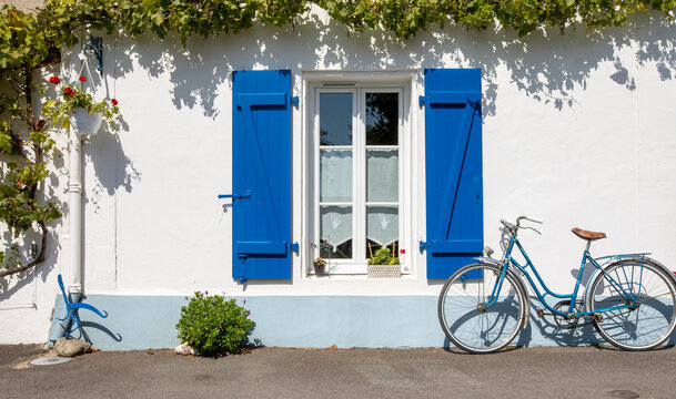 Vieux v&eacute;lo bleu en fa&ccedil;ade d'une maison sur l'&icirc;le de Noirmoutier en Vend&eacute;e.
