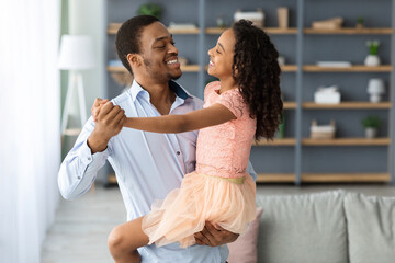 Loving african american father dancing with his little daughter