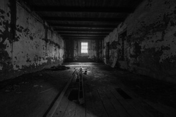 Grayscale of an old building warehouse with a window