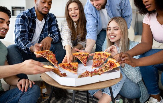 Happy Multiracial Friends Chatting, Eating Pizza Together, Having Small Party At Home