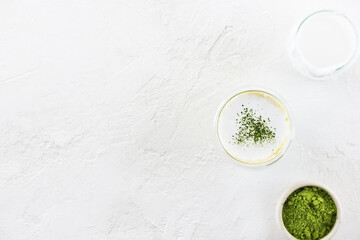Matcha latte tea with coconut milk in a glass on a light background. Horizontal orientation, top view, copy space.