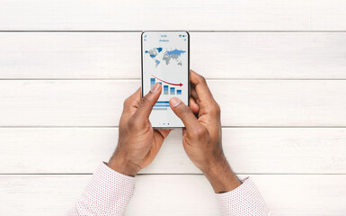 African american businessman using financial app on smartphone