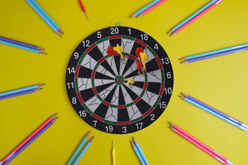 View from above of an office table and desk. Workspace with a dart board with a target and a...