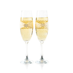 Two glasses of champagne decorated for the wedding with lace and wooden heart.