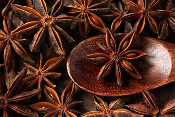 Obraz na płótnie Canvas macrophotography of star anise on a wooden background. tubs lies in a brown wooden spoon