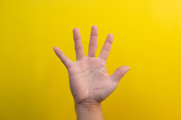 Naklejka premium close up hand on yellow background