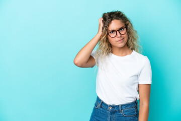 Girl with curly hair isolated on blue background with an expression of frustration and not understanding