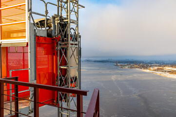A landscape view of a construction elevator at the height of a construction site.