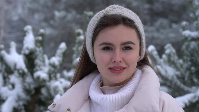 Young attractive woman smiles in winter in the park