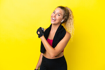 Sport woman with towel isolated on yellow background celebrating a victory