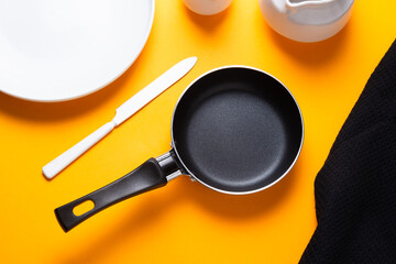 Black metal nonstick frying pan, on yellow background