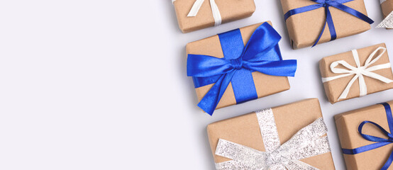 Banner with gifts tied with ribbons on a blue background. Festive creative layout with copy space.