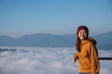 Fototapeta na wymiar Portrait of a young female traveler with a beautiful mountain and sea of fog