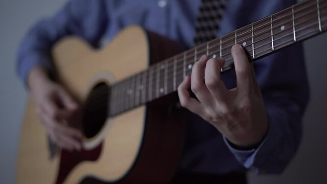 Guitar player hand with pick playing solo on acoustic guitar. Singer songwriter, sample pack for modern bedroom producer. Concept of music school and production