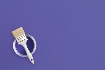 Paint brush with an open can of paint on trendy Very Peri background. Color of the year 2022. Top...