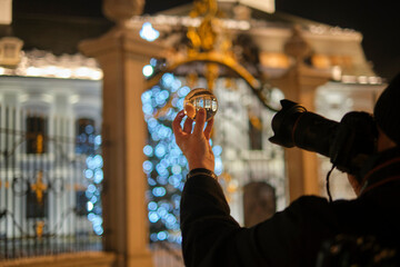Photographer is shooting through crystal ball Christmas palace