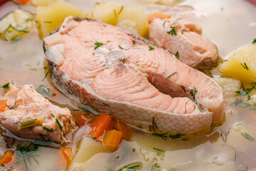 Fish soup. Large pieces of red fish (trout) in the soup.
