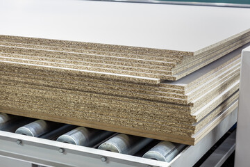 particle boards are stacked on a wood-cutting machine