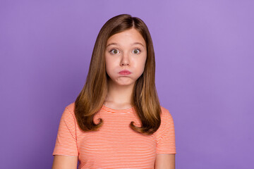 Portrait of attractive funky brown-haired girl holding air in cheeks isolated over vibrant violet...