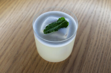 cocktail with white foam and mint on a wooden table for advertising