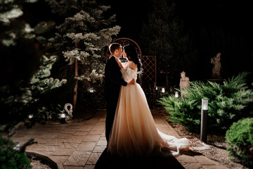 gentle and happy bride and groom in wedding dresses on the evening street.