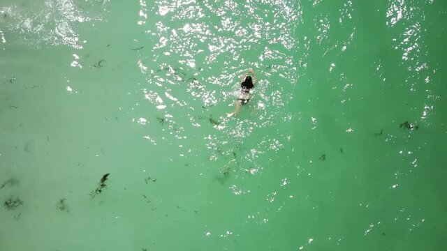 Chica nadando en el mar plano drone aereo desde arriba