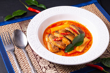 Thai food concept Thai coconut milk red curry duck in white ceramic soup plate with herbs thai style background and copy space