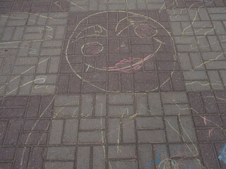 Simbol of the happiness and peace. Children's drawings on the asphalt. The grafic image applied with chalk on the surface of the paving slabs