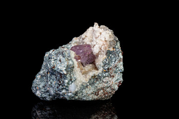 macro mineral amethyst stone in rock on a black background