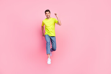 Fototapeta na wymiar Full size profile photo of funny brunet hairdo millennial guy run wear green t-shirt jeans isolated on pink color background