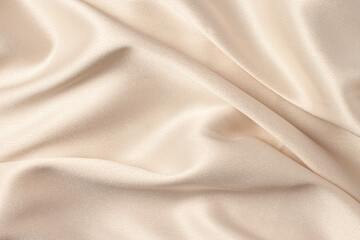 Silk atlas soft tender beige color fabric with shiny curves and waves macro