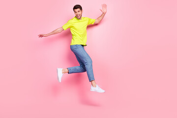 Fototapeta na wymiar Full length body size view of attractive cheerful guy jumping walking having fun isolated over pink pastel color background