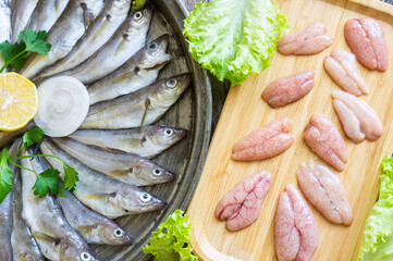 Uncooked haddock caviar with fresh haddock fish on wooden background