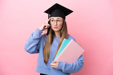 Young student woman wearing a graduate hat isolated on pink background having doubts and thinking