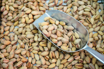 dried pistachios are poured and a shovel for picking up goods by weight