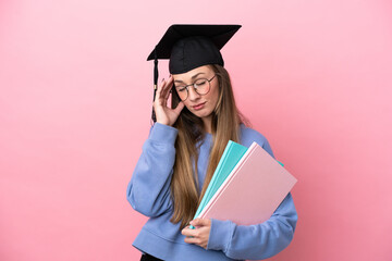 Young student woman wearing a graduate hat isolated on pink background with headache