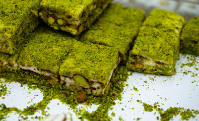 Pistachio sweets in nougat sprinkled with pistachio powder