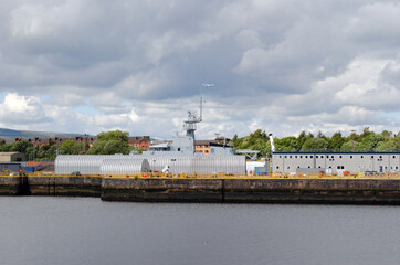Fototapeta premium View of Riverside Industrial Dock with Naval Vessel