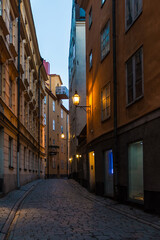 Fototapeta na wymiar Perspective view of historical buildings on the Tyska Skolgrand Alley at twilight, Stockholm, Sweden 
